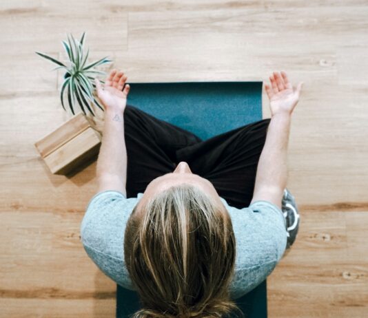 스트레스 관리의 새로운 열쇠, 마음 챙김의 힘 woman in black shirt and gray pants sitting on brown wooden bench
