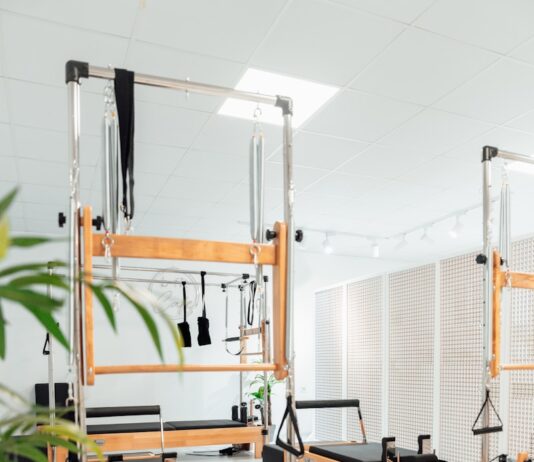 필라테스, 체형 교정과 건강을 한 번에 잡는 운동법 a room filled with lots of machines and a plant