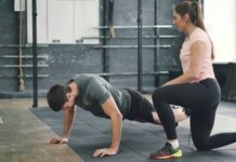 집에서도 쉽게 시작하는 근육 건강, 일상 속 탄탄한 습관이 열쇠 Man doing push-ups with a trainer spotting him.